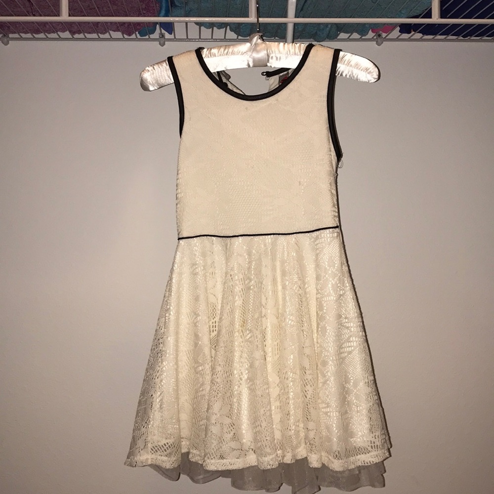 New,white laced sleeveless dress with a black trim